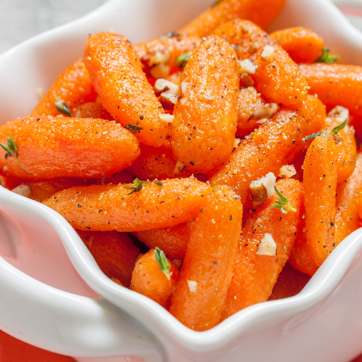 Air fryer baby carrots garnished with fresh herbs, showcasing their golden brown color and caramelized glaze.