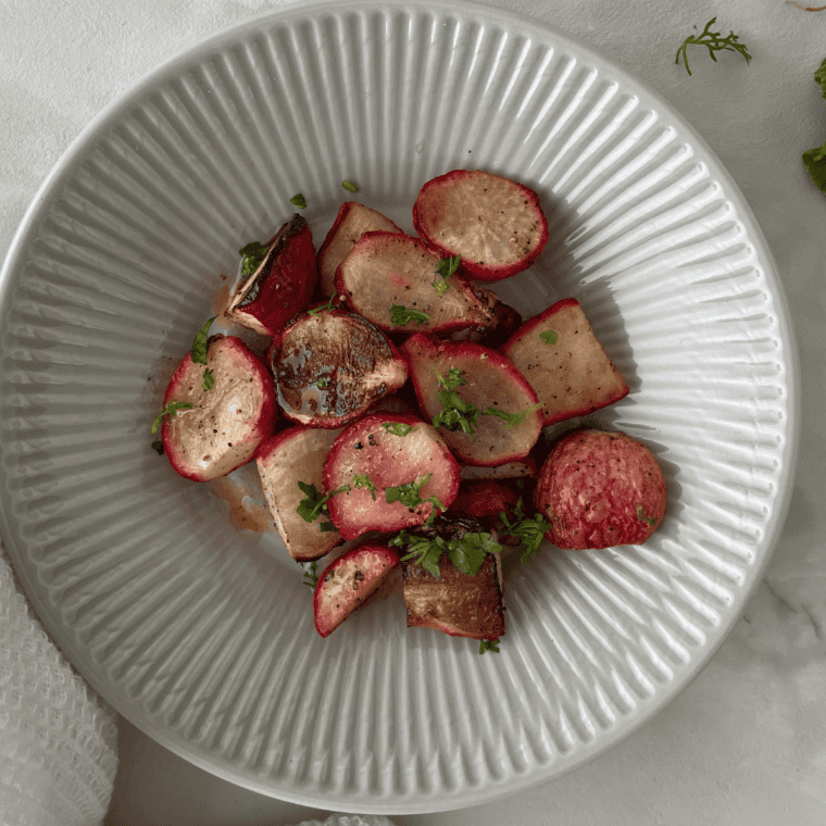 A plate of crispy, golden Air Fryer Roasted Radishes, garnished and ready to serve.