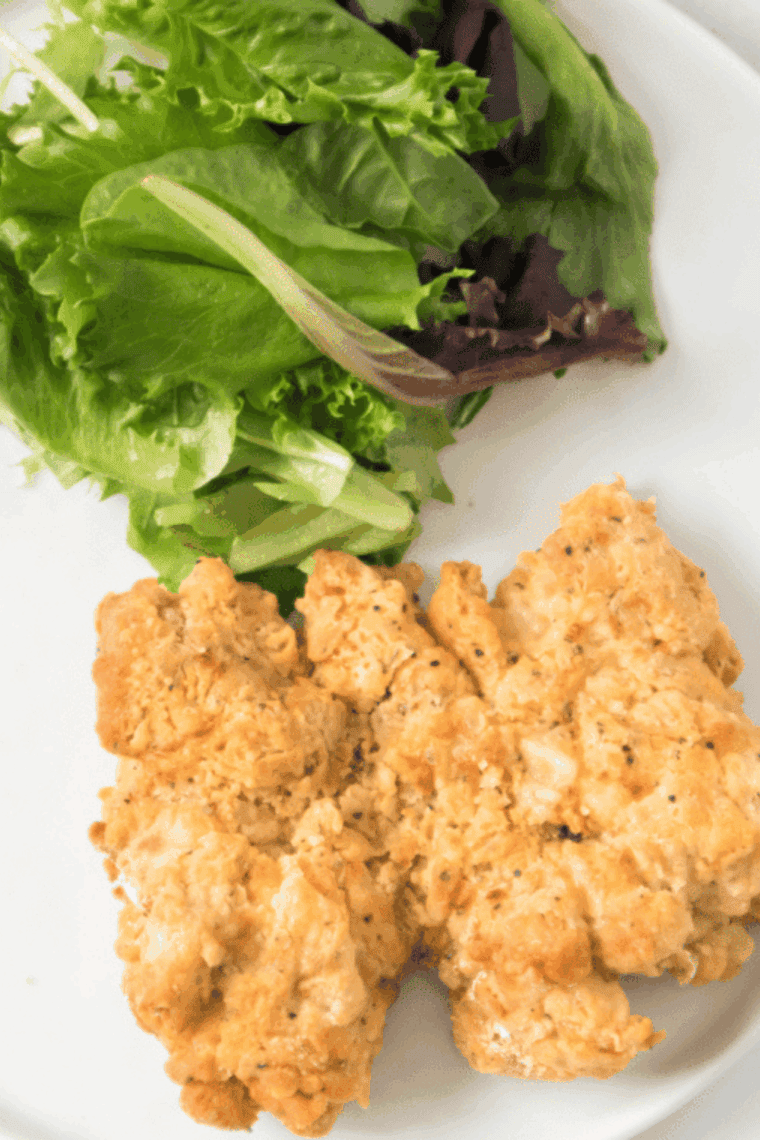 Plate of Bob Evan's Fried Chicken Copycat Recipe on the kitchen table with a simple salad.