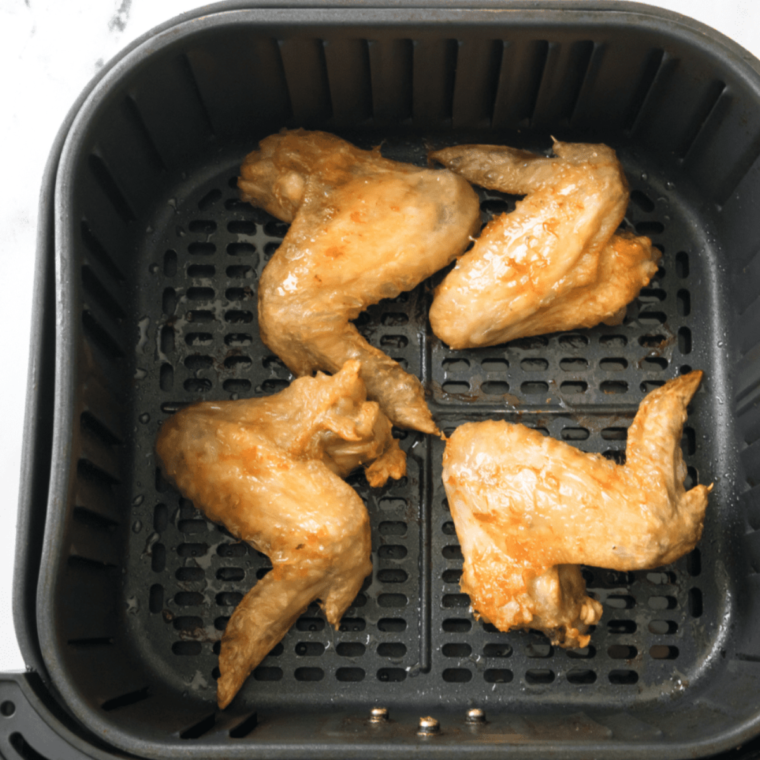 Preparing Buffalo Wild Wings Lemon Pepper Wings, with chicken wings tossed in lemon pepper seasoning in a mixing bowl.