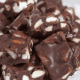 Stack of thick copycat Buc-ee's rocky road fudge squares with mini marshmallows and toasted pecans