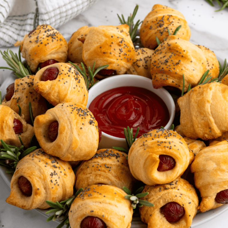 Frozen pigs in a blanket cooked to golden perfection in the air fryer, served with a side of dipping sauces.