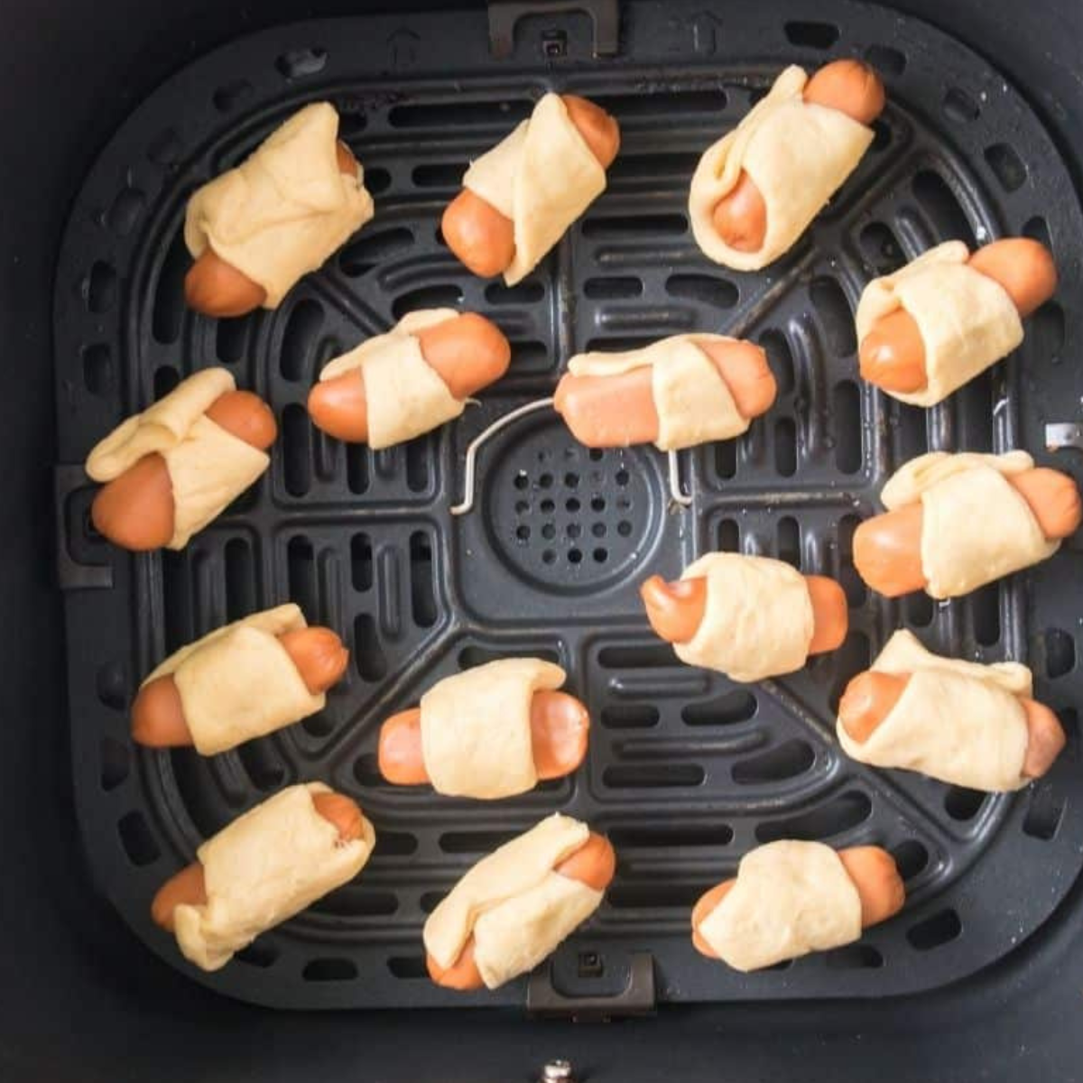 Place frozen pigs in the blanket in the air fryer basket.