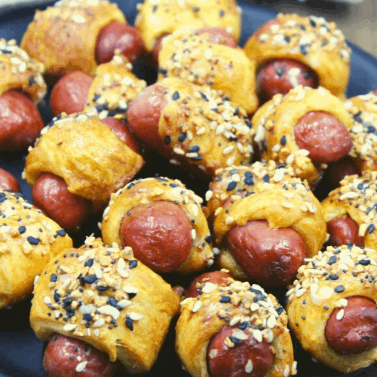 Air fryer frozen pigs in a blanket served crispy and golden brown with a variety of dipping sauces.