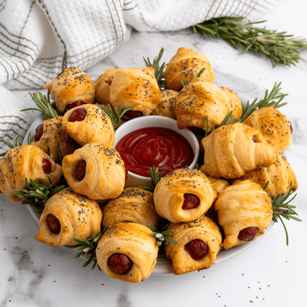 Crispy frozen pigs in a blanket made in the air fryer, served hot with dipping sauces on the side.