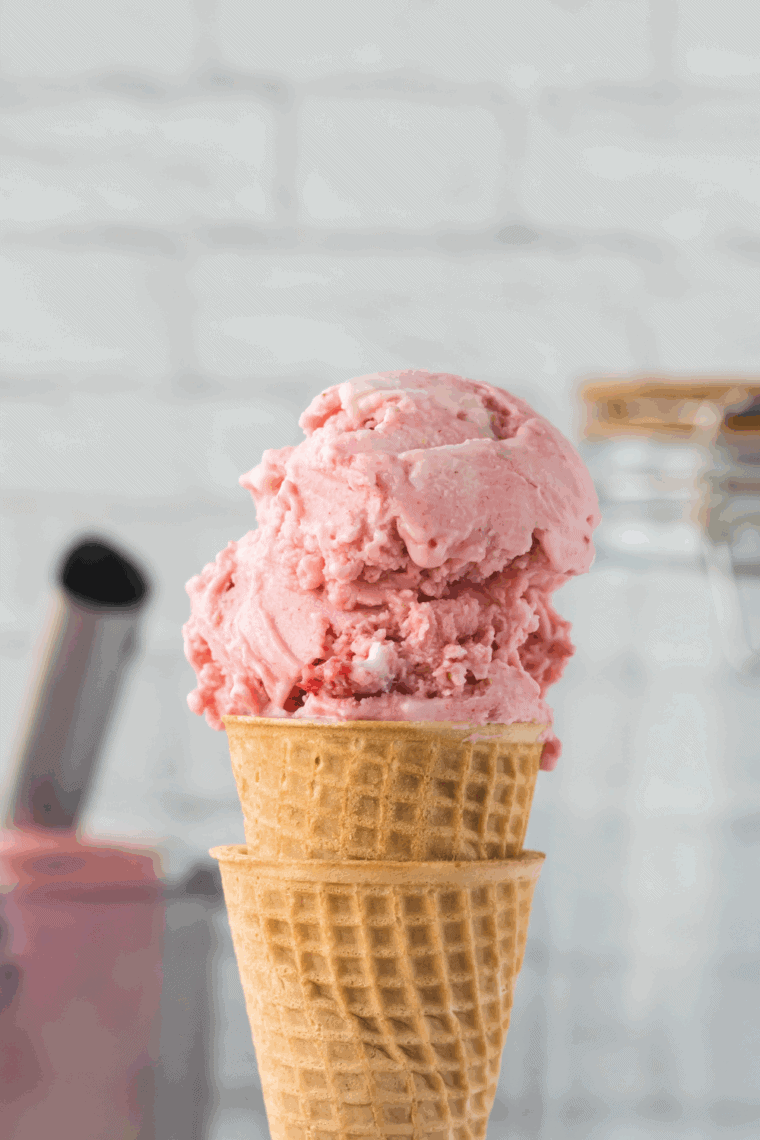 Ninja Creami strawberry ice cream served in a dessert dish with fresh strawberries.