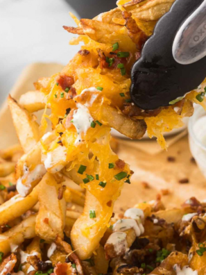 Copycat Red Robin Voodoo Fries topped with queso, crumbled bacon, fried jalapeños, and ghost pepper sauce