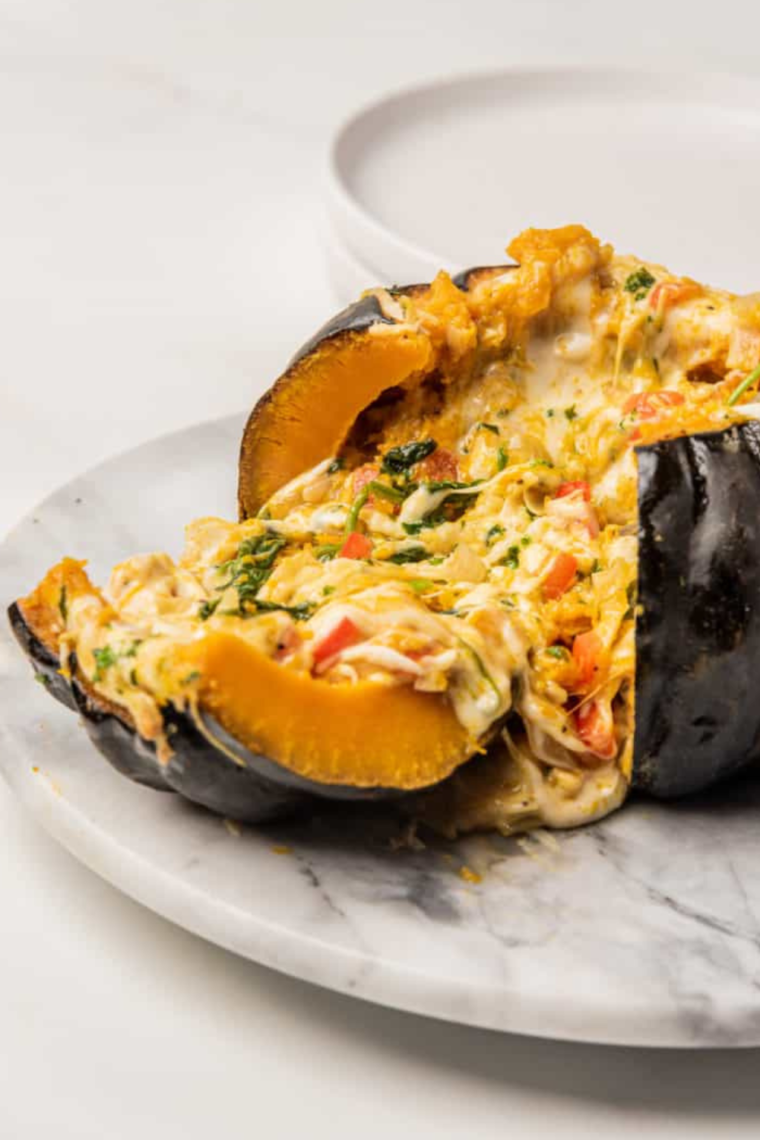 Plated stuffed Air Fryer kabocha squash garnished with fresh herbs.