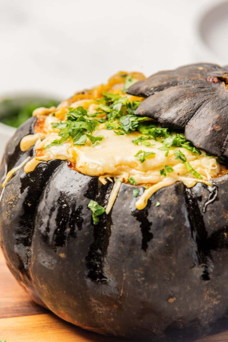 Plated stuffed Air Fryer kabocha squash garnished with fresh herbs.