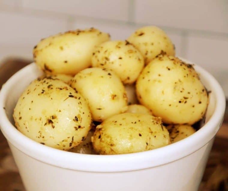 Cooked canned potatoes in a white serving bowl. 