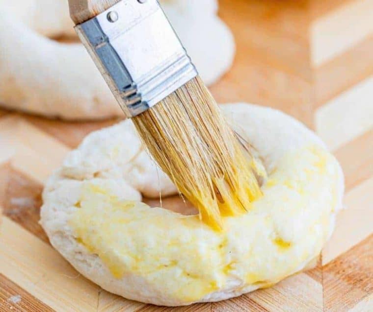 Egg wash being brushed onto a 2 ingredient bagel 