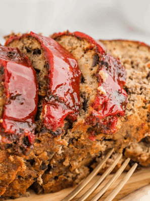 A colorful platter featuring a variety of savory side dishes served alongside a classic meatloaf.