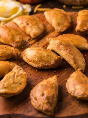 Golden brown air fried empanadas resting on a wire cooling rack