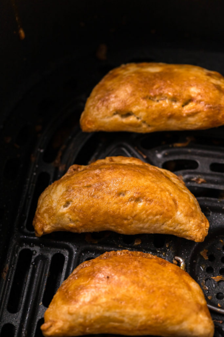 Empanadas cooking in the air fryer basket at 375 degrees