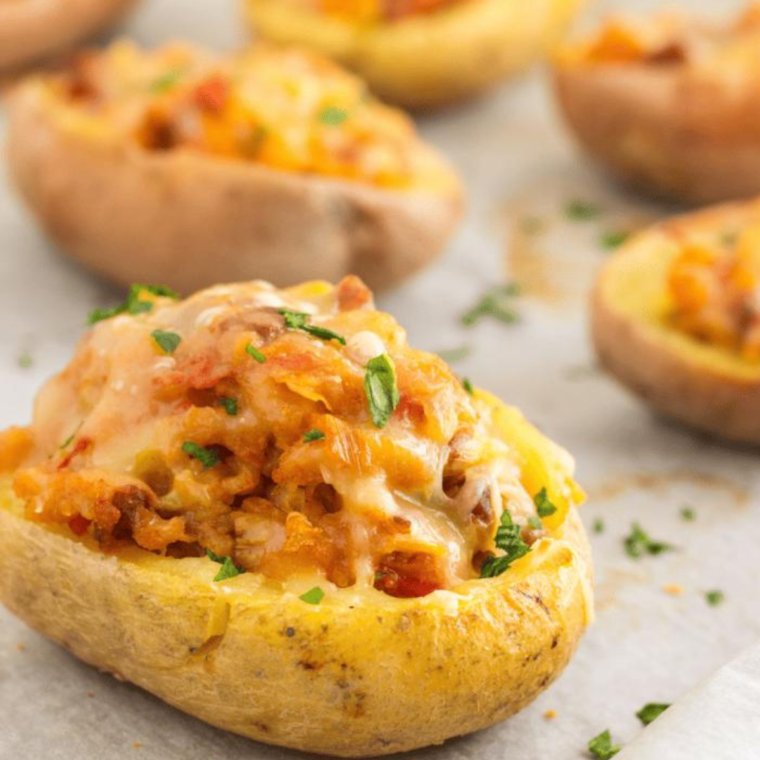 Plated baked jacket potato with melted cheese, sour cream, and fresh chives."