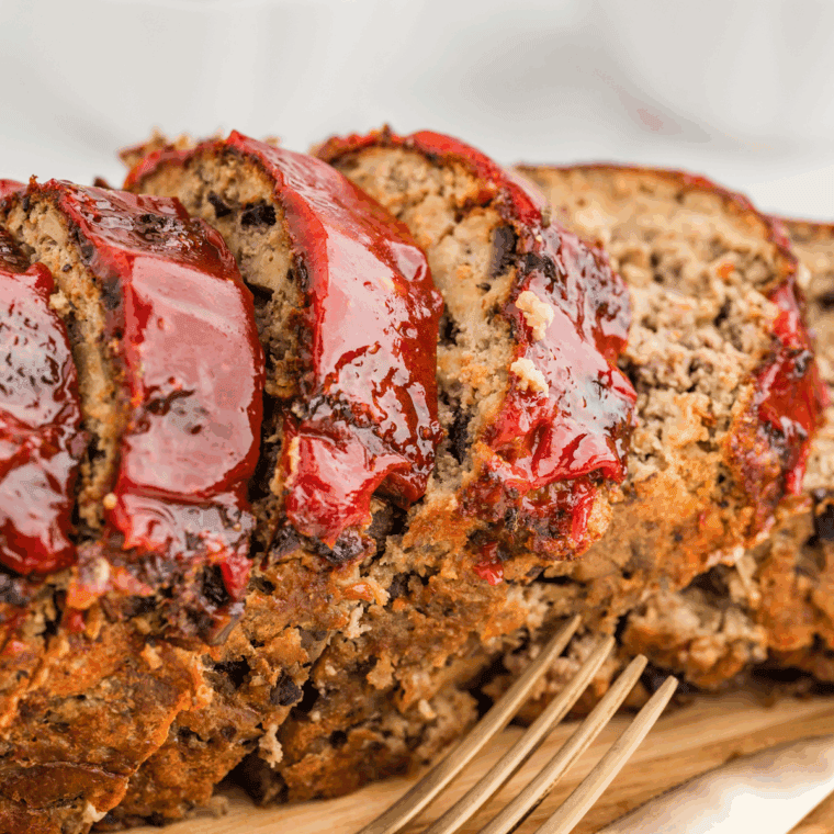Reheated meatloaf slices in air fryer basket with crispy edges