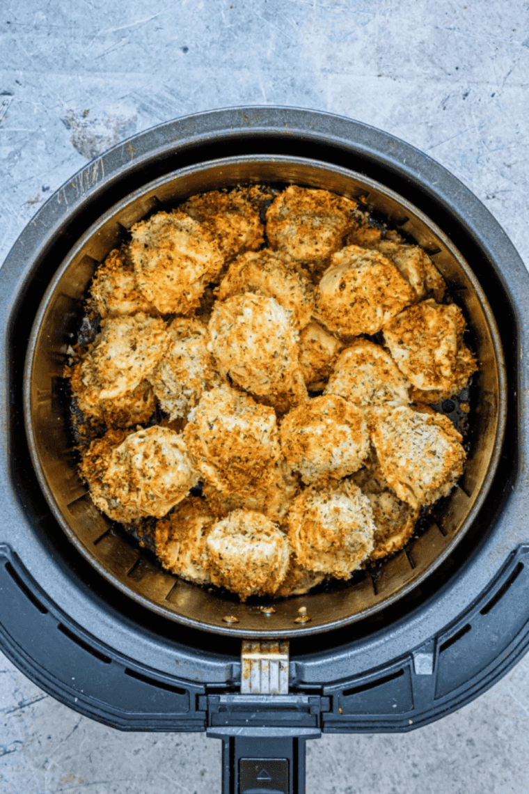air fryer tortellini coated in seasoning cooking in air fryer basket