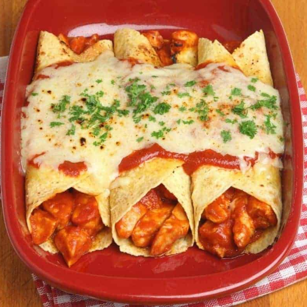 Serving reheated enchiladas straight from the air fryer on a plate.