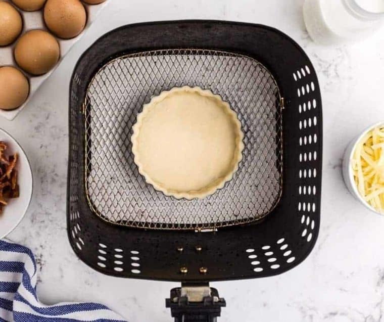 tart pan with pie crust in air fryer basket