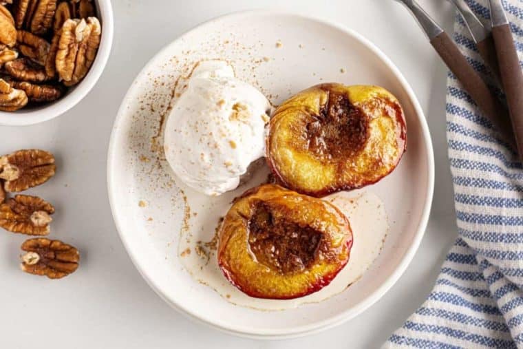 Top view of fried peaches and ice cream on a white plate. 