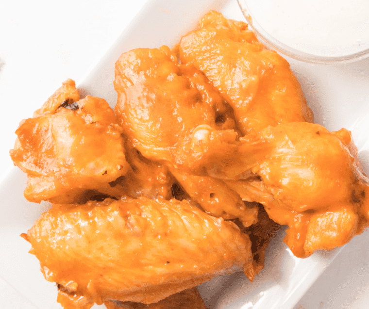 plate of buffalo chicken wings with ranch dressing on the side