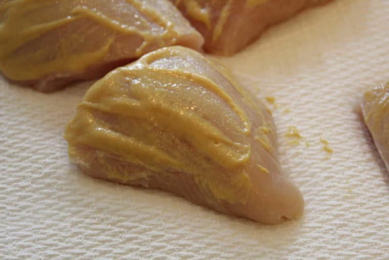 chicken breasts slathered in honey mustard on paper towel