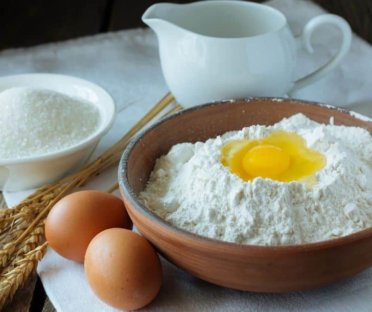 egg cracked into bowl of dry ingredients