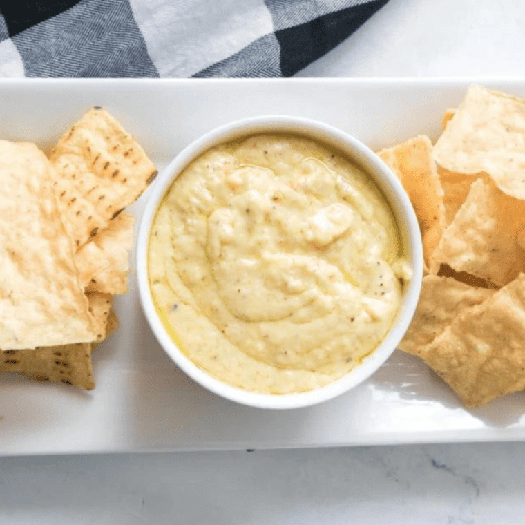 Bowl of creamy white cheddar beer cheese sauce served with pretzels for dipping.