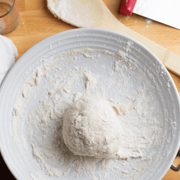 Kneading dough on a floured surface until smooth, then letting it rise in a covered, oiled bowl until doubled in size.