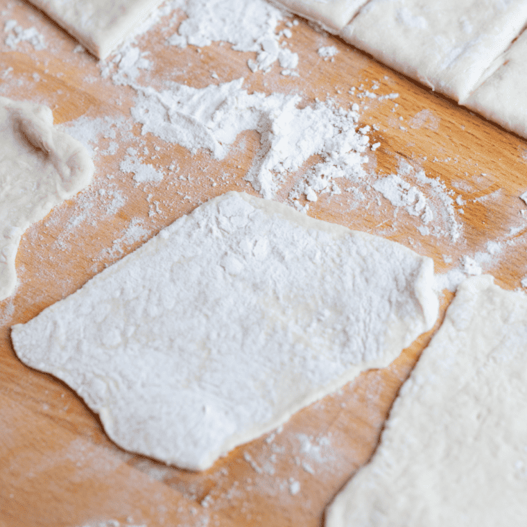 Punching down risen dough, dividing into balls, and rolling into thin circles for perfect puffing in the air fryer.