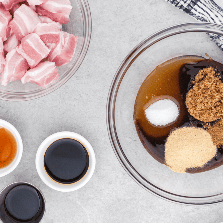 Raw pork belly cubed into 1-inch pieces on a wooden cutting board for air fryer honey glazed pork belly bites