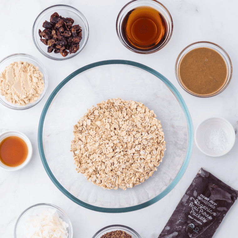 Mixing rolled oats, acai puree, almond butter, honey, and other ingredients in a bowl to make protein balls.