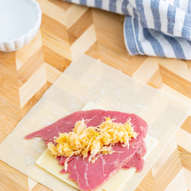 Draining sauerkraut in a kitchen towel to remove liquid, mixed with Russian dressing in a small bowl.