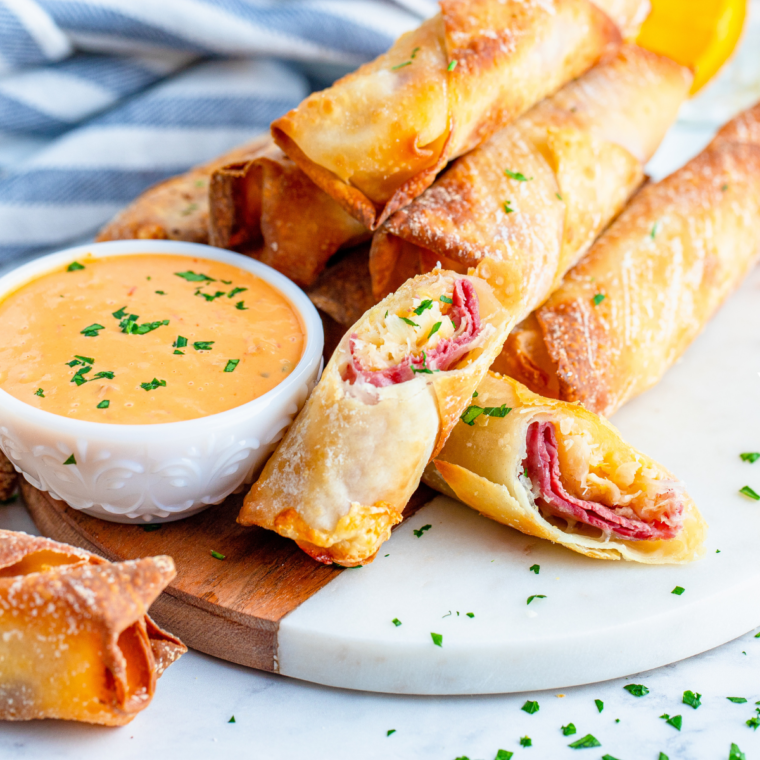 Golden, crispy Air Fryer Reuben Egg Rolls with corned beef, Swiss cheese, sauerkraut, and Russian dressing.