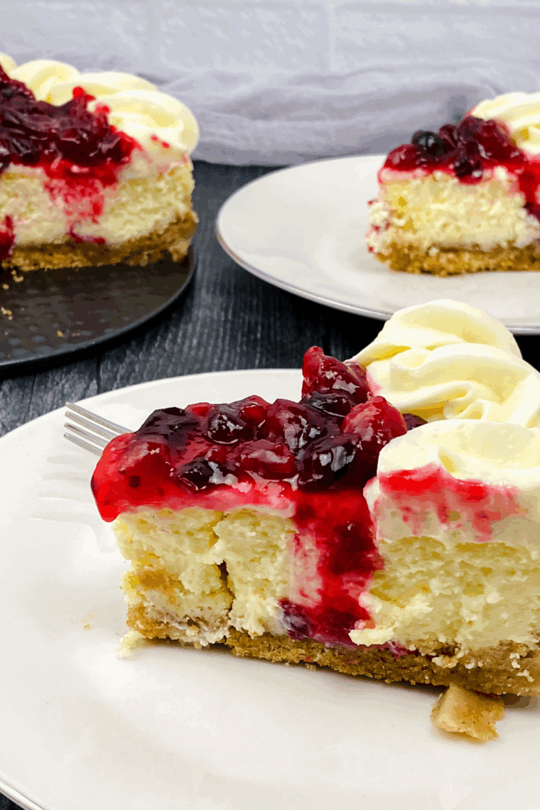 Slice of creamy Cheesecake Factory Cranberry Cheesecake topped with glossy cranberry sauce.