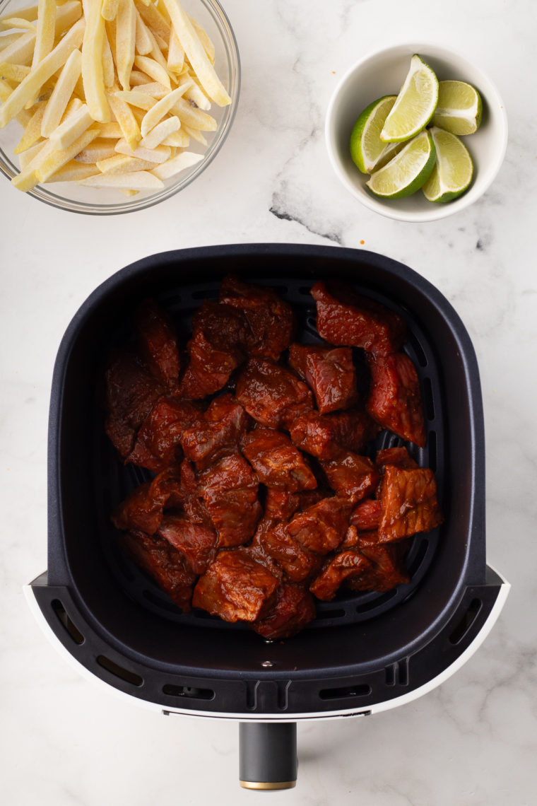 Preheating the air fryer to 375°F for 3-5 minutes and adding the coated beef chunks into the air fryer basket in a single layer, cooking for 8-10 minutes.