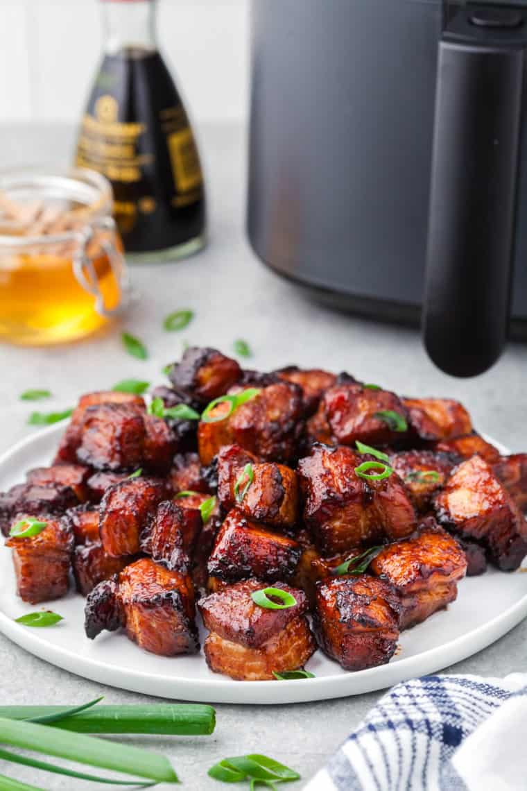 Honey glazed pork belly bites served over jasmine rice in a ceramic bowl with chopsticks