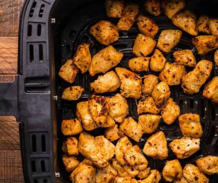 top view of cubed chicken in air fryer basket to show how to air fry chicken bites. 