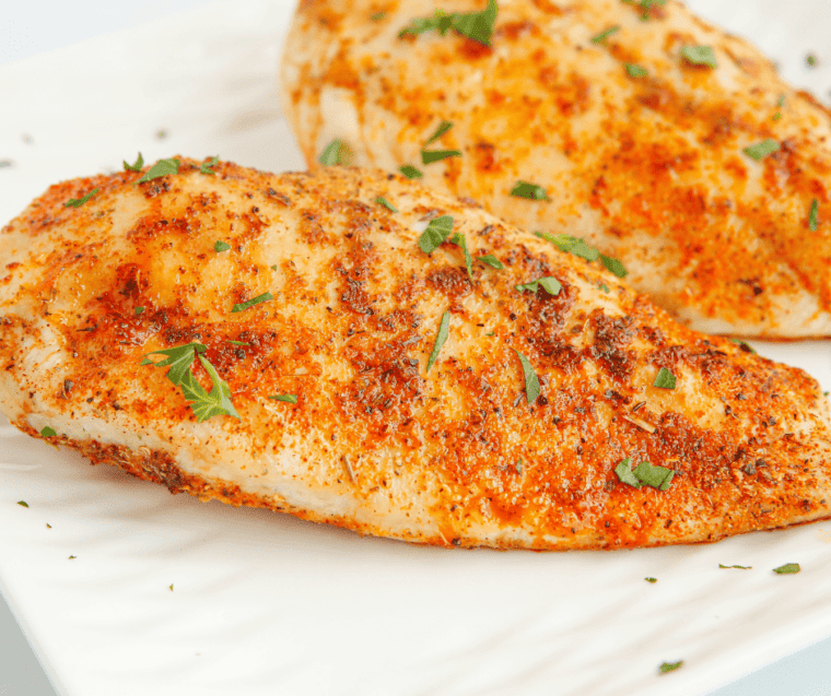 close up: air fried chicken breasts with seasoning and fresh parsley