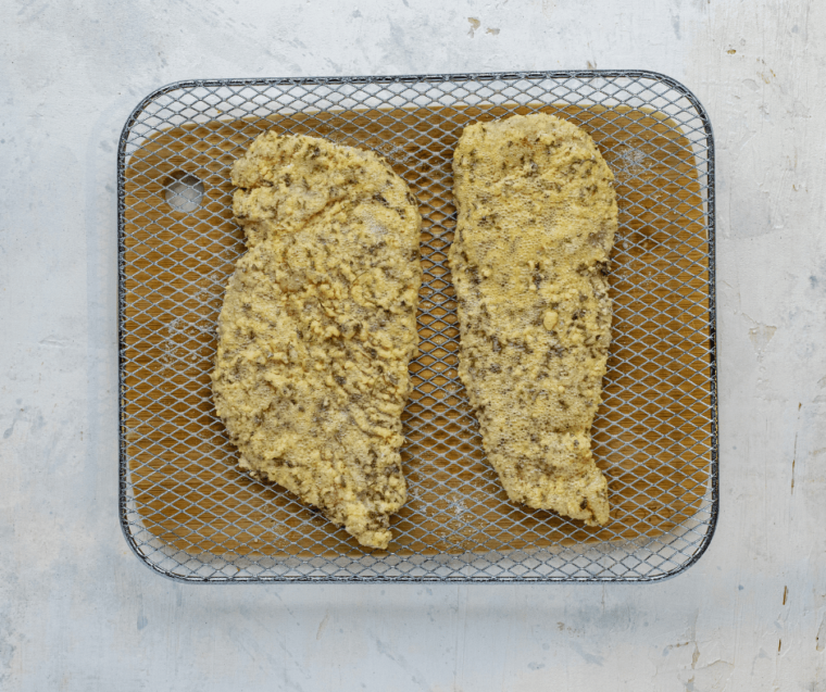 lemon caper chicken cutlets on wire rack over cutting board