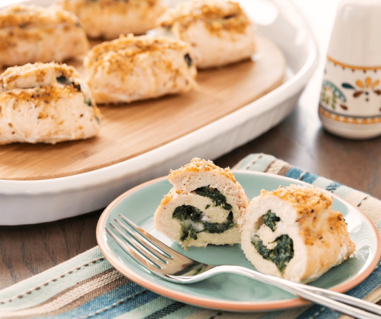 spinach and cheese stuffed chicken breast cut open on plate