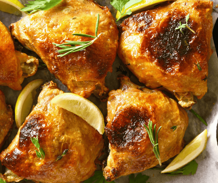air fried chicken thighs topped with lemon slices and fresh rosemary