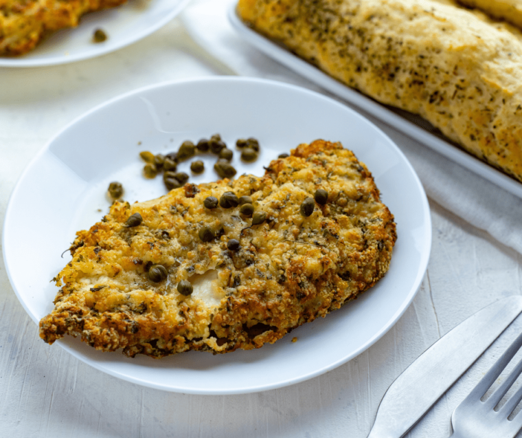 breaded chicken cutlet with capers on white plate
