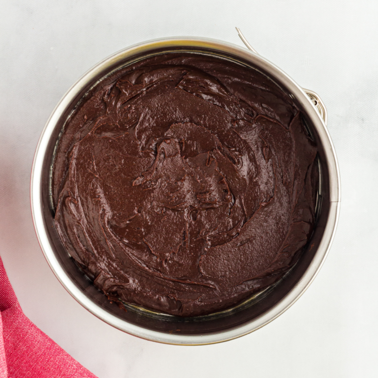 Brownie batter spread evenly in a six-inch springform pan, ready for the air fryer
