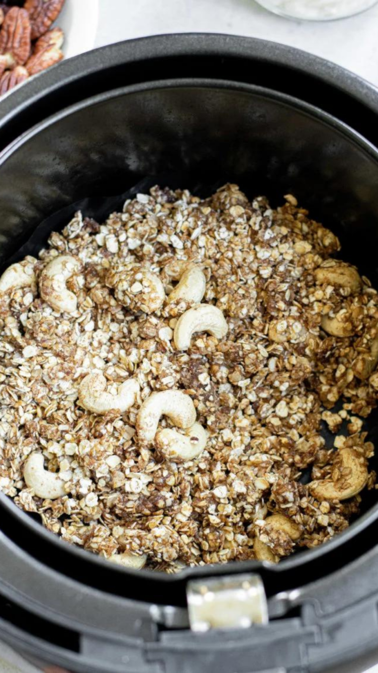 Cranberry Granola in air fryer basket, in a single layer being cooked.