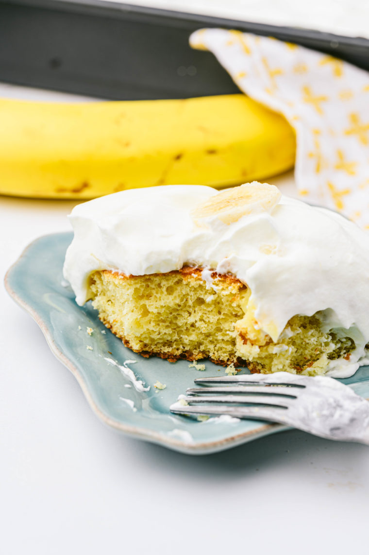 "Close-up of Air Fryer Banana Poke Cake with whipped cream and banana slices"