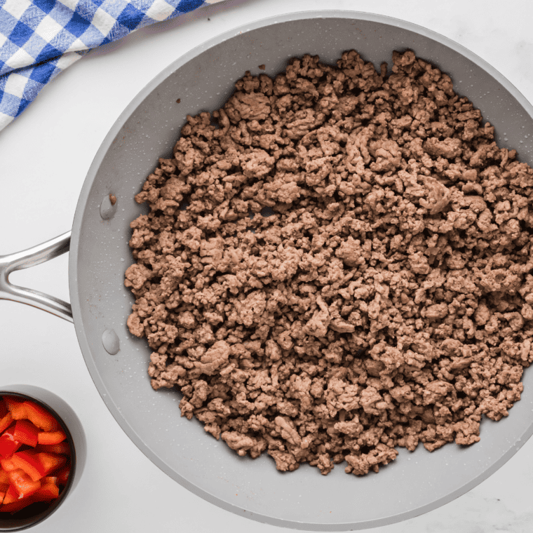 Ground beef browning in a large skillet over medium heat.