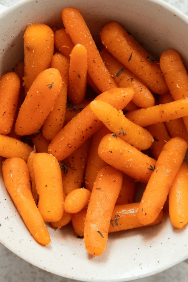 A bowl of Cracker Barrel-style glazed carrots, featuring tender, orange carrots glistening with a sweet glaze, served as a comforting side dish.