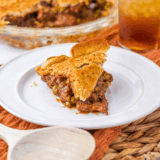 Air fryer beef pot pie in a white ramekin with a golden flaky crust cut open to show tender beef, carrots, and peas in brown gravy