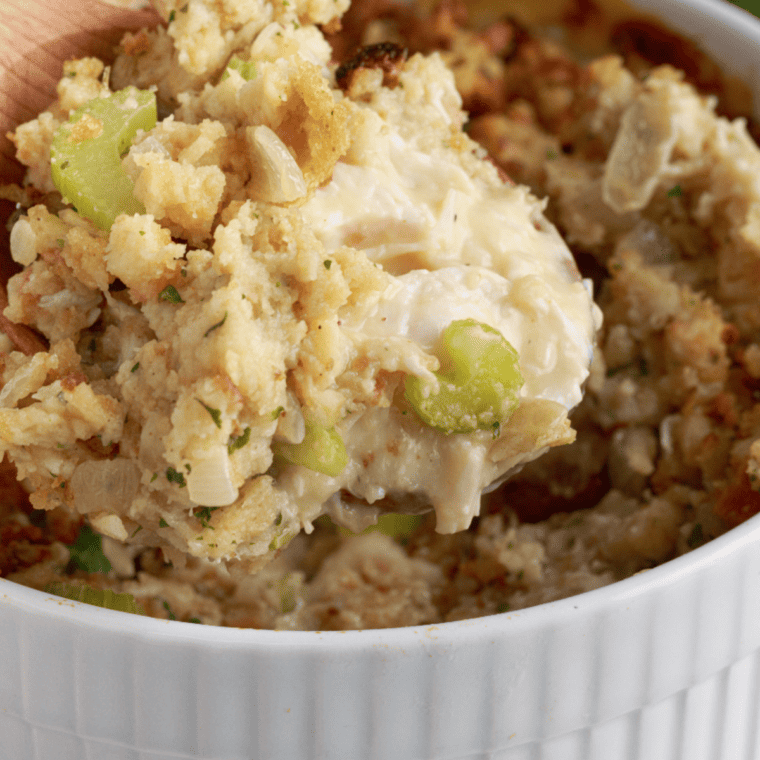 Serving dish with air fryer chicken and stuffing casserole garnished with fresh herbs.